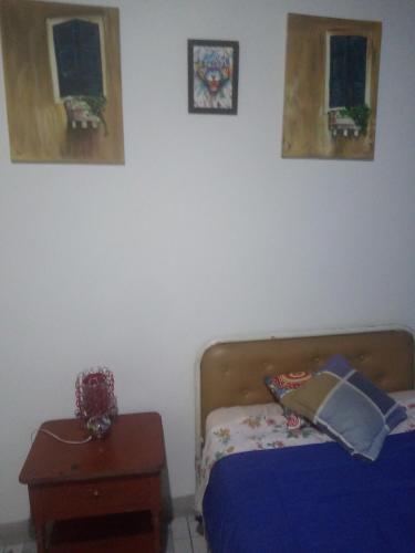 基多Hotel Tanta Wasi-Panecillo的卧室配有一张床,墙上挂有两张照片