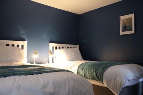 亨格福德The Tally Ho的卧室设有两张床铺和蓝色的墙壁
