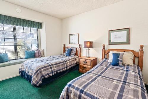 大熊湖013 - Mountain Haven Condo的一间卧室设有两张床和窗户。