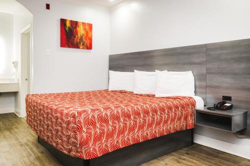 休斯顿宫殿290旅馆 - 费尔班克斯的酒店客房,配有一张带红色毯子的床