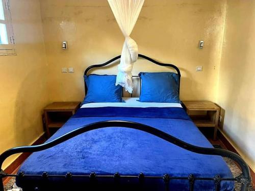 格雷岛Petit Studio - île de Gorée的一间卧室配有蓝色的床、蓝色的床单和蓝色的枕头