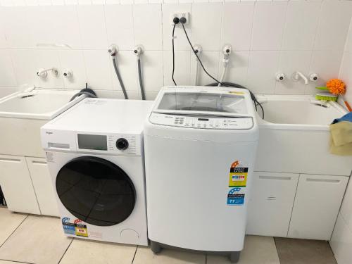 布里斯班197 Shafston Ave Kangaroo Point QLD 4169的浴室内配有洗衣机和水槽。