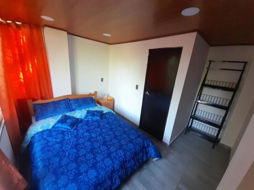 派帕El encanto的一间卧室设有蓝色的床和黑色的门