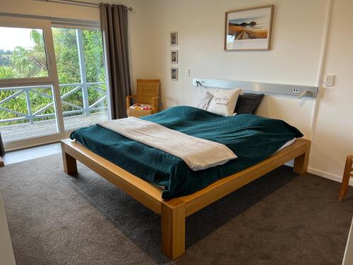 图图卡卡Tutukaka Sunrise的一间卧室配有一张带绿毯的床和窗户。