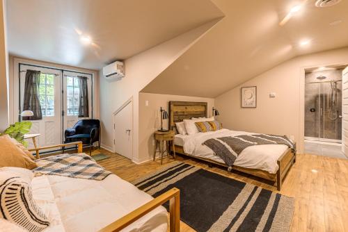 魁北克市St. Ursule Two-Storey Oasis的阁楼卧室配有两张床和椅子
