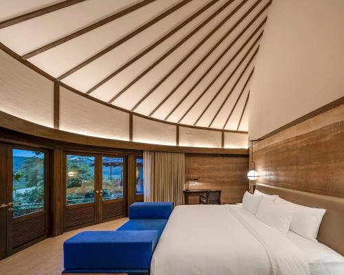 南府Patamma Hideaway Resort的一间卧室配有一张大床和蓝色的椅子