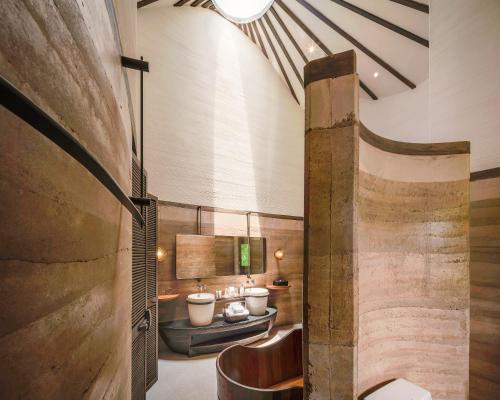 南府Patamma Hideaway Resort的一间带石墙和水槽的浴室