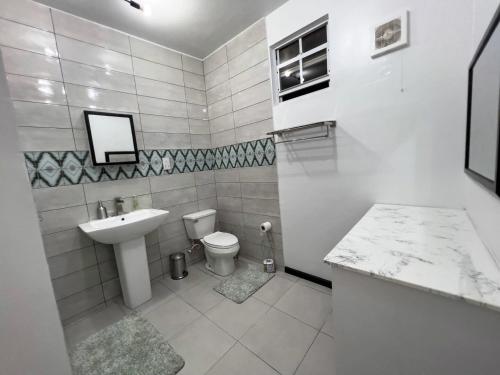 格罗斯岛Chalet Belizomi Tropical Villas Studio Villa #3的白色的浴室设有水槽和卫生间。