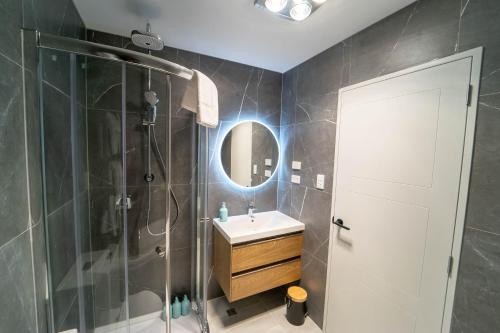 奥克兰Modern Sunnyhills Town House的带淋浴、盥洗盆和镜子的浴室