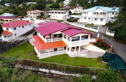 格罗斯岛Chalet Belizomi Tropical Villas Studio Villa #3的享有粉红色屋顶房屋的空中景致