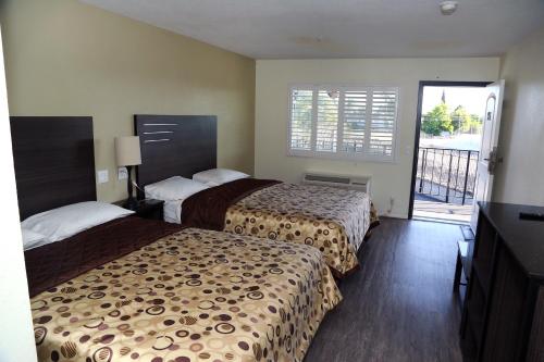 安大略Airport Stay Motel的酒店客房设有两张床和一个阳台。