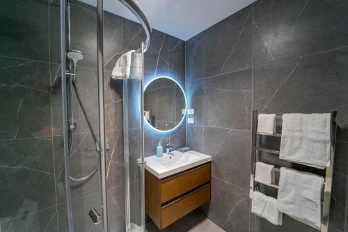 奥克兰Sunnyhills Viewside Town House的浴室配有盥洗盆和带镜子的淋浴