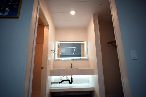 安大略Airport Stay Motel的浴室设有白色水槽和镜子