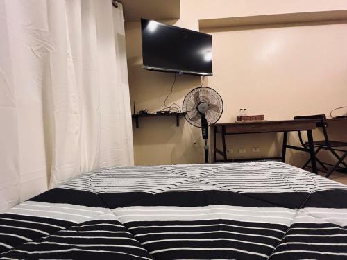 伊洛伊洛C Comfortable Avida Room的一间卧室配有一张床和一台平面电视