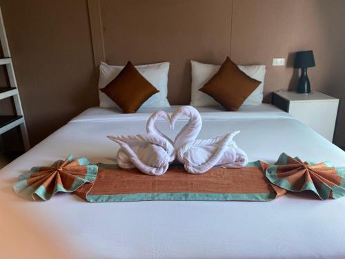 皮皮岛上坡村舍酒店的两条毛巾放好,看起来像天鹅在床上