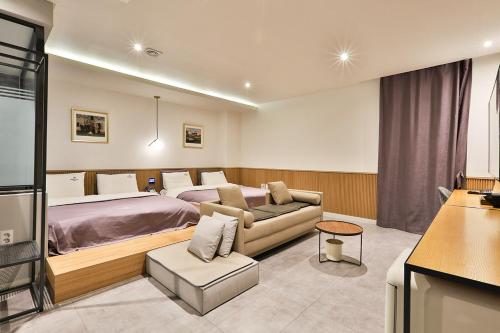 釜山Brown Dot Hotel Jeonggwan的酒店客房,配有床和沙发