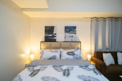 马尼拉A2J Luxury 2BR BGC Suite Near SM Aura, Market2x的一间卧室配有一张床和一张沙发