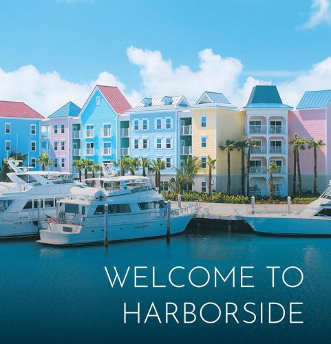 拿骚Harbourside Resort, Paradise Island Bahamas的一群船停靠在码头,有建筑物