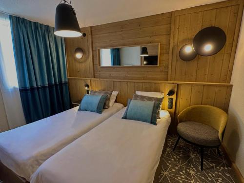 贝勒普拉涅Hôtel L'Eden des Cimes - Vacances Bleues - Belle Plagne 2100的酒店客房,配有两张床和椅子