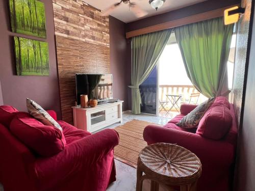 波德申Glory beach private PD的客厅配有2张红色沙发和1台电视