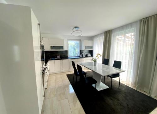 BlankenhagenFewo II Familie Sobierajczyk的厨房以及带白色桌椅的用餐室。