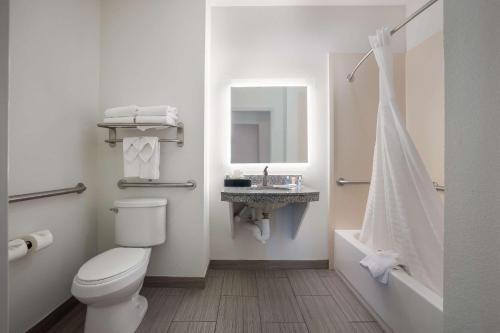 德纳姆斯普林斯德纳姆泉康福特套房酒店的浴室配有卫生间、盥洗盆和浴缸。