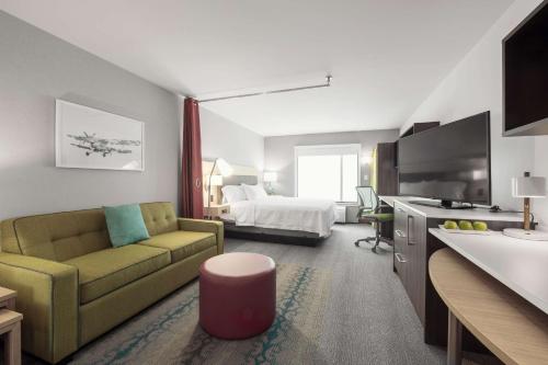 魁北克市Home2 Suites By Hilton Quebec City的酒店客房设有一张沙发和一张床