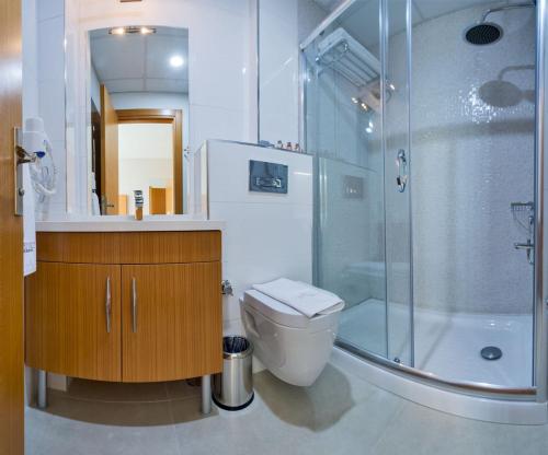 伊斯坦布尔Mıen Hotels的一间带卫生间和玻璃淋浴间的浴室