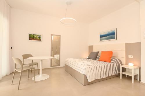 维耶斯泰Agorà Vieste Rooms & Apartments的卧室配有一张床和一张桌子及椅子