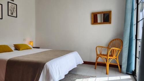 蒂亚斯Casa Julia的卧室配有床、椅子和窗户。