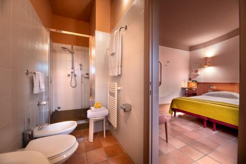 潘札诺La Pensione di Vignamaggio的浴室设有床、卫生间和水槽。