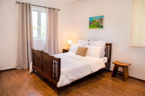 格兰高伯Island Villa的一间卧室配有一张带白色床单的床和一扇窗户。