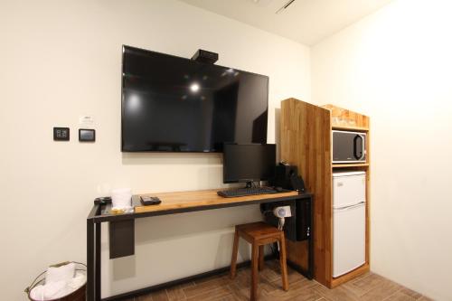 首尔第31页酒店的一间设有一张桌子的房间,墙上配有电视