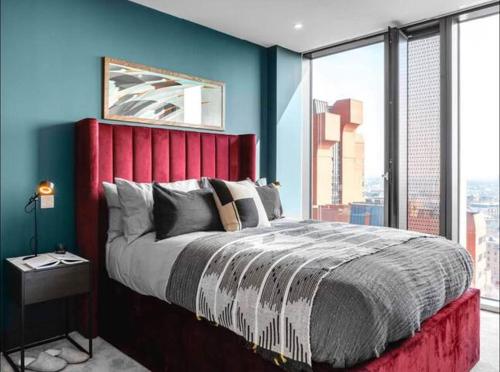 伯明翰The Mercian Luxury Apartments Birmingham City Centre - Your Perfect Stay Apart hotels- 24 Hour Gym Rooftop Terrace Cinema Room的一间卧室配有一张大床和红色床头板
