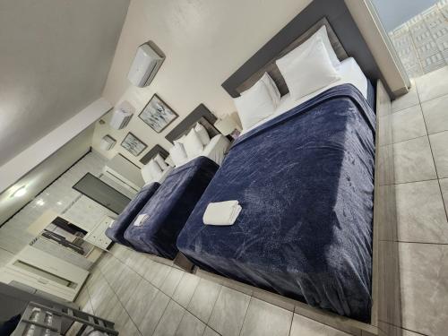 卡罗利纳The Village Inn的一间卧室配有两张带蓝色床单和白色枕头的床