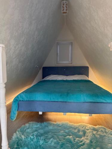 博罗沃耶Афреем дом的阁楼卧室配有蓝色床