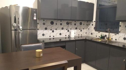 科伦坡MercuryFM 105 House Colombo 3 - Schofield pl 3-2的厨房配有桌子和不锈钢冰箱。