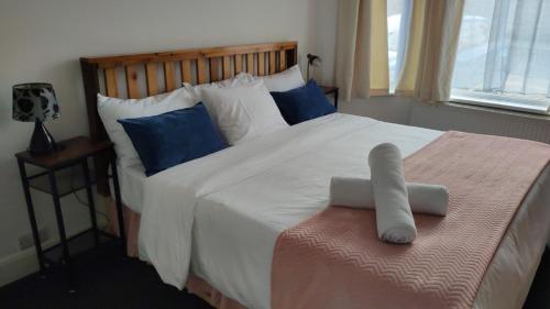 桑当Fair Oak Self-Catering Accomodation的卧室配有带蓝色枕头的大型白色床