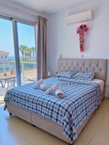 珊瑚湾3 Bedroom Coral Bay Beach Seaview Villa II Private Pool的一间卧室配有一张带蓝白格子毯子的床
