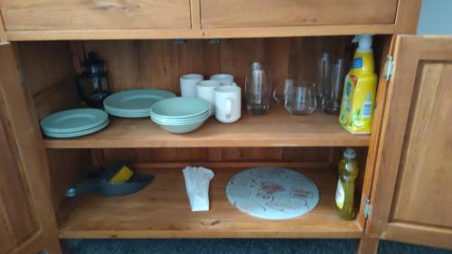 桑当Fair Oak Self-Catering Accomodation的木柜,上面有盘子和盘子