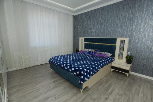 巴库Welcome Inn的一间卧室配有一张带蓝色和白色棉被的床