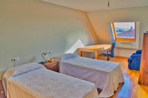 里贝拉Illas Atlánticas的客房设有两张床、一张桌子和镜子