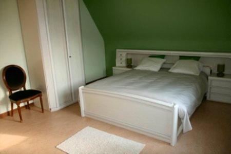 HertsbergeB&B Heerlijkhyd的卧室配有白色的床和绿色的墙壁
