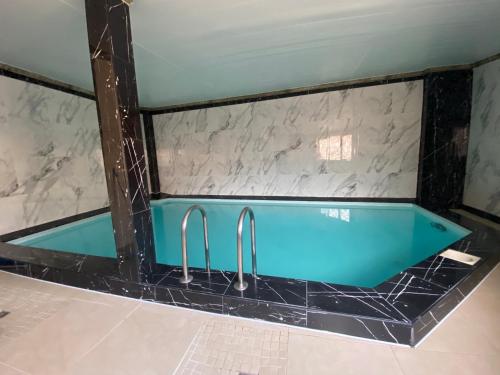 里加Apartamenti的浴室设有蓝色的浴缸,拥有大理石墙壁