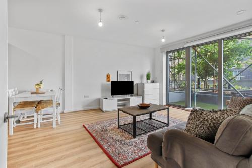 伦敦Centrally Located Modern 2Bed 2Bath Apartment的客厅配有沙发和桌子