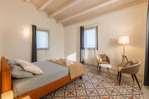 CossignanoRelais Tenuta Santori的一间卧室,卧室内配有一张床和一把椅子