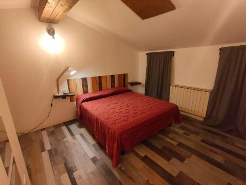 Villanovacasa vacanze Villanova - 4 posti letto的一间卧室配有一张红色棉被的床