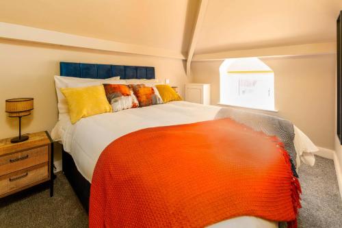 莫克姆Clock Tower Retreat - Sea View Apartments in Morecambe的一间卧室配有一张带橙色毯子的大床