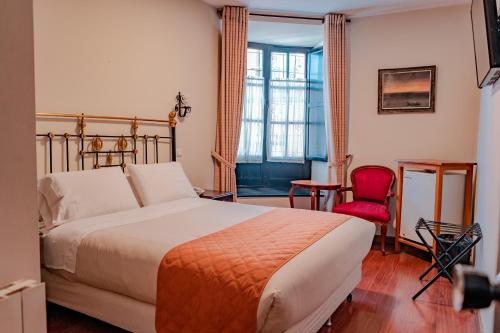 波托西Hostal Colonial Potosi的酒店客房,配有一张床和一张红色椅子