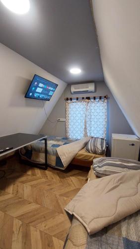 乌斯怀亚Habitacion en casa de familia的阁楼间配有床和平板电视